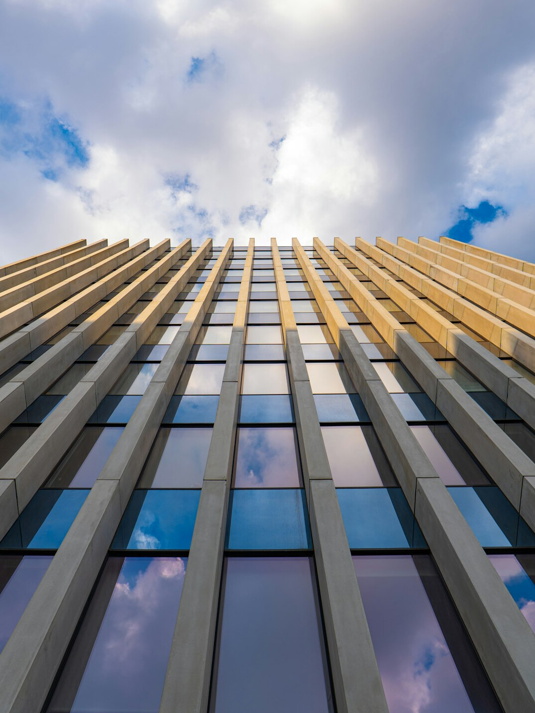 Glass facade of a modern office building seen from below