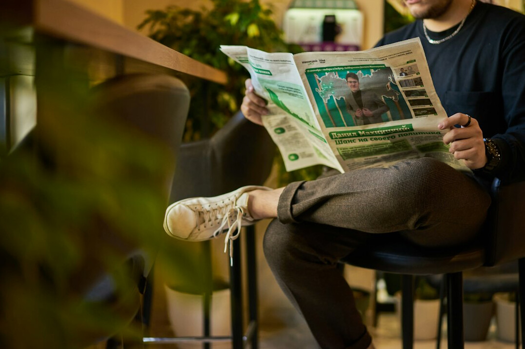 person reading newspaper about climate